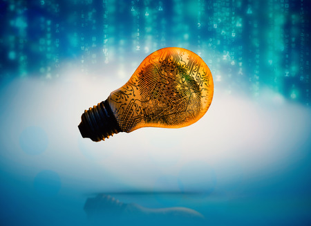 Lines of blue blurred letters falling against digital circuit board inside light bulbの写真素材