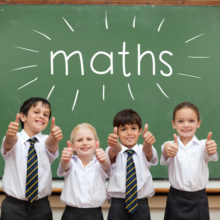 The word maths against cute pupils showing thumbs up in classroomの写真素材