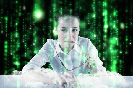 Businesswoman typing on a keyboard against lines of green blurred letters fallingの写真素材