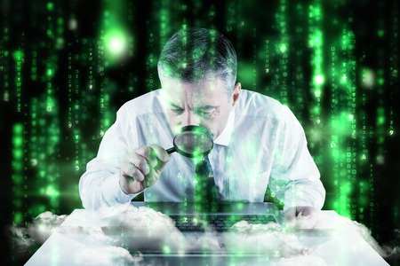 Mature businessman examining with magnifying glass against lines of green blurred letters falling