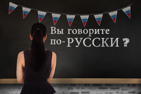 Standing businesswoman against blackboard on wallの写真素材