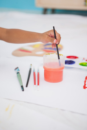 Cute little boy painting on floor in classroom at the nursery schoolの写真素材