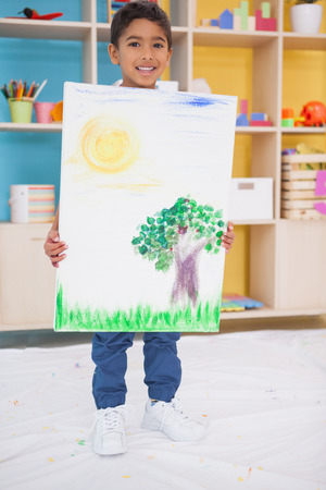 Cute little boy showing his painting in classroom at the nursery schoolの写真素材