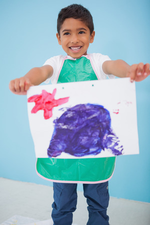 Cute little boy showing his painting in classroom at the nursery schoolの写真素材