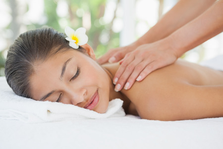 Beautiful brunette enjoying a shoulder massage at the health spaの写真素材
