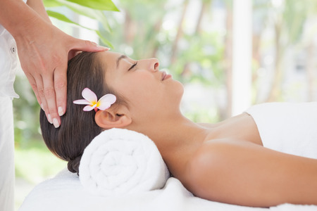 Beautiful brunette enjoying a head massage at the health spaの写真素材