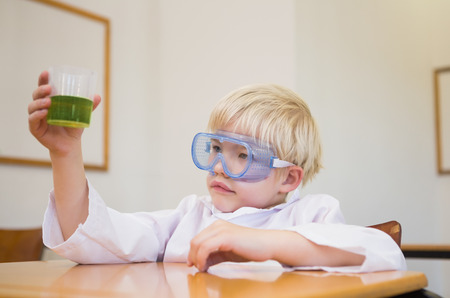 Cute pupil dressed up as scientist in classroom at the elementary schoolの写真素材
