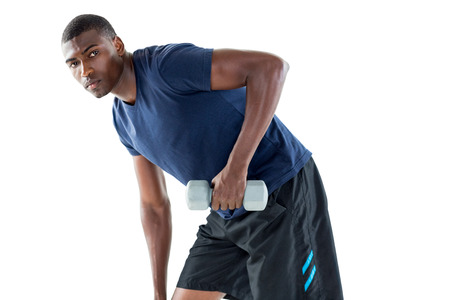 Portrait of a casual young man lifting dumbbell over white background