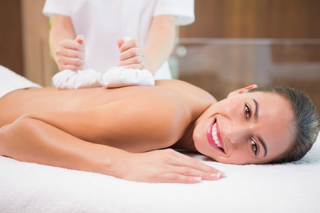 Side view of an attractive young woman receiving treatment at spa centerの写真素材