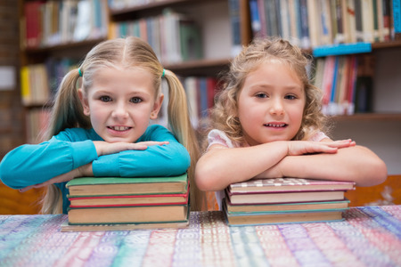 Cute pupils smiling at camera in library at the elementary schoolの写真素材