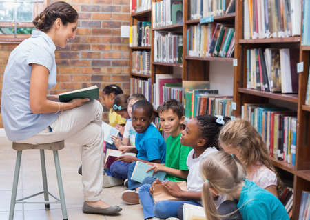 Cute pupils sitting on floor in library at the elementary schoolの写真素材