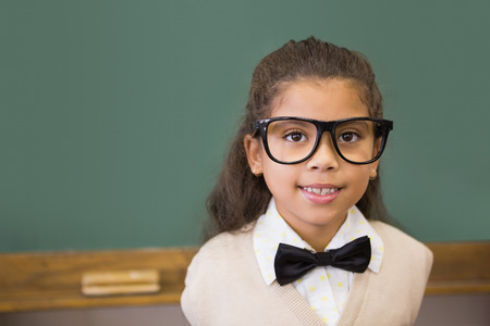 Cute pupil dressed up as teacher in classroom at the elementary school