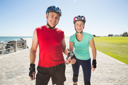 Fit mature couple rollerblading on the pier on a sunny dayの写真素材
