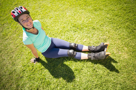 Fit mature woman in roller blades on the grass on a sunny day