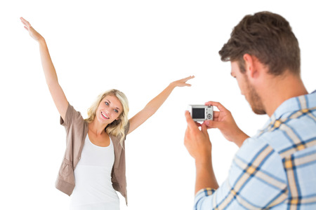 Man taking photo of his pretty girlfriend on white backgroundの写真素材