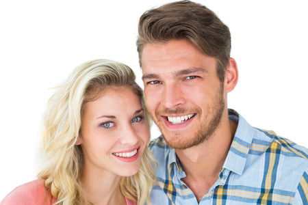 Attractive young couple smiling at camera on white backgroundの写真素材