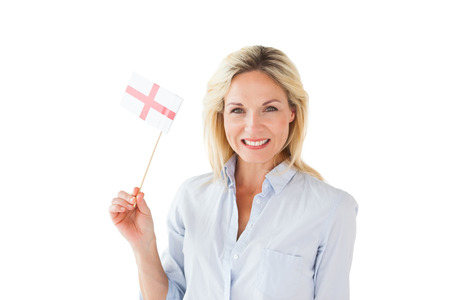 Smiling blonde woman holding english flag on white backgroundの写真素材