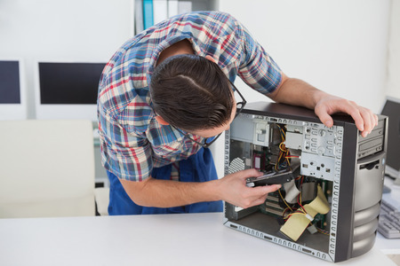 Computer engineer working on broken console in his officeの写真素材