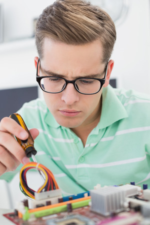 Technician working on broken cpu with screwdriver in his officeの写真素材