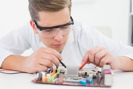 Technician working on broken cpu with soldering iron in his officeの写真素材