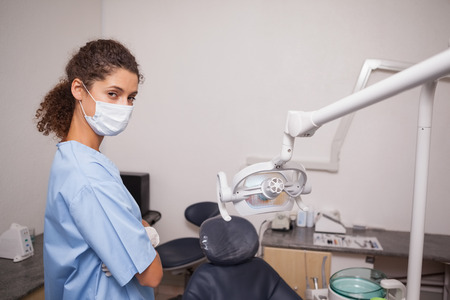 Dentist in surgical mask looking at camera at the dental clinicの写真素材