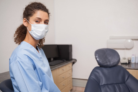 Dentist in surgical mask looking at camera at the dental clinicの写真素材