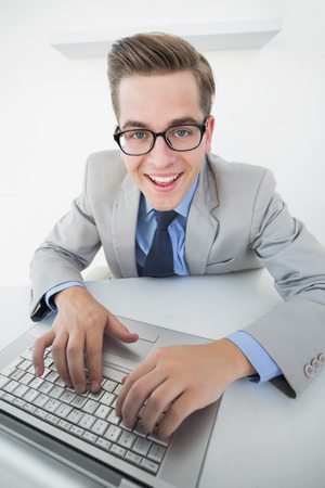 Excited businessman working on laptop in his officeの写真素材