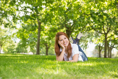 Pretty redhead relaxing in the park on a sunny dayの写真素材