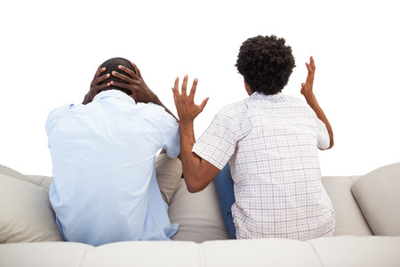 Rival sports fans sitting on the couch on white backgroundの写真素材
