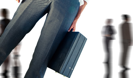 Businessman holding briefcase against silhouettes of business peopleの写真素材