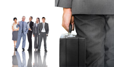 Composite image of businessman holding briefcase against group of business peopleの写真素材