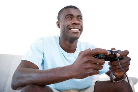 Casual man smiling and playing video games on white backgroundの写真素材