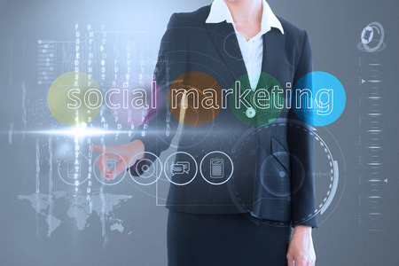 Businesswoman touching the words social marketing on interface against grey vignetteの写真素材