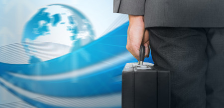 Businessman holding briefcase against global business graphic in blueの写真素材