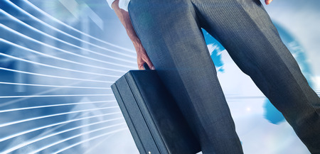 Businessman holding briefcase against global business graphic in blueの写真素材
