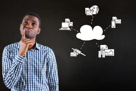 Young businessman thinking against black with business technology doodleの写真素材