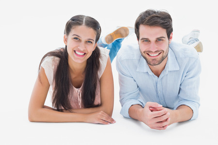 Attractive young couple smiling at camera on white backgroundの写真素材