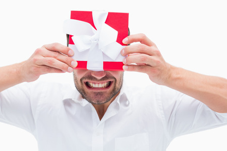 Stressed man holding a present on white background