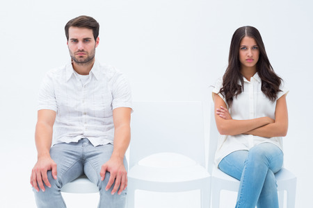 Angry couple not talking after argument on white backgroundの写真素材