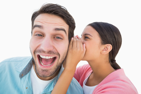 Brunette whispering secret to her boyfriend on white background