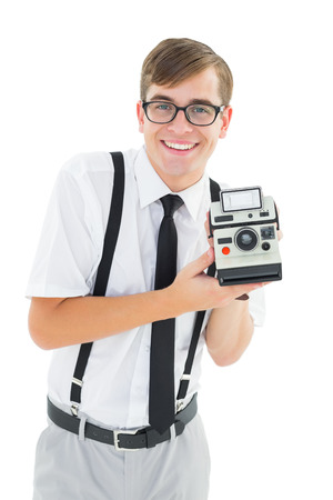 Geeky hipster holding a retro camera on white backgroundの写真素材
