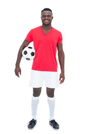 Football player in red jersey holding ball on white backgroundの写真素材