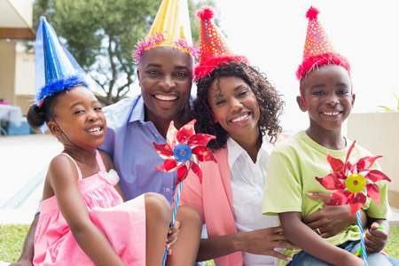 Happy family celebrating a birthday together in the garden on a sunny dayの写真素材