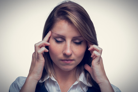 Close up of beautiful young businesswoman with headache over white backgroundの写真素材