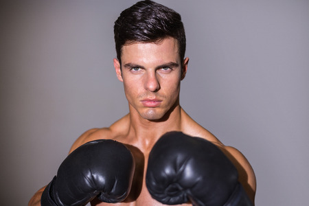 Close-up portrait of a shirtless muscular boxer over white backgroundの写真素材