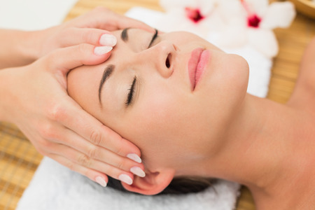 Smiling brunette enjoying a head massage in the health spaの写真素材
