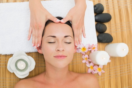 Smiling brunette enjoying a head massage in the health spaの写真素材