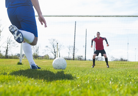 Goalkeeper in red ready to save a penalty on a clear dayの写真素材
