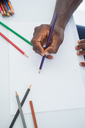 Man drawing with colour pencils in his officeの写真素材