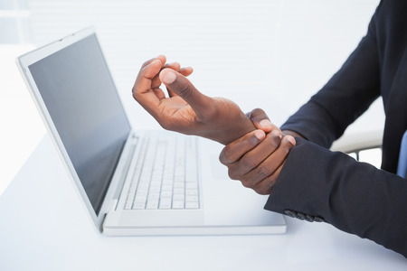 Businessman holding his sore wrist from typing in his officeの写真素材